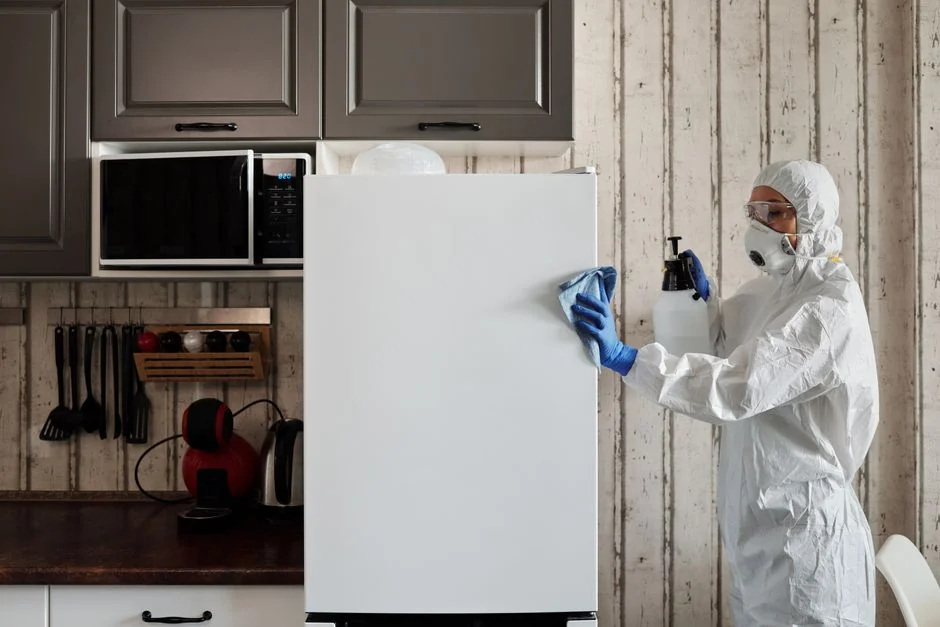 Une femme emballe avec soin un canapé dans un matériau de protection, tout en préparant des cartons dans une pièce lumineuse.